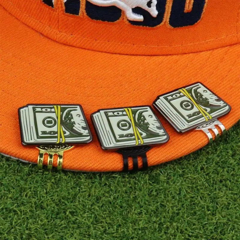 Set of three dollar design golf ball markers in black, stainless steel and gold attached to a golf hat brim with magnetic clips
